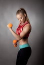 Young athletic woman works out with dumbbells