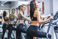 young athletic women working out on elliptical machines