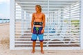 Young attceractive guy surfer stands on the beach looking out into the distance, Royalty Free Stock Photo