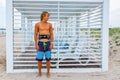 Young attceractive guy surfer stands on the beach looking out into the distance, Royalty Free Stock Photo