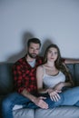 , attentive couple watching tv on sofa Royalty Free Stock Photo