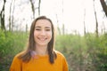 Young and attracive woman standing and laughing in the woods