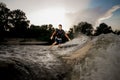 Young attractive active man riding on the wakeboard on the lake Royalty Free Stock Photo