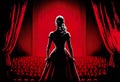 An young attractive actress in long dress standing on a theatre stage. Back view. Red and black illustration. Created with Royalty Free Stock Photo