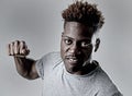 Young attractive african american black man in rage threaten punching with fist in angry upset Royalty Free Stock Photo