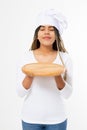 Young attractive african american woman in cooking hat holding empty wood pizza cutting board isolated on white background. Copy Royalty Free Stock Photo