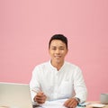 Young attractive asian businessman using laptop sitting on desk table in office Royalty Free Stock Photo