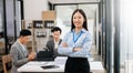 Young attractive Asian female office worker business suits smiling at camera in office