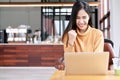 Young attractive asian female student using laptop computer smiling with excited at cafe coffee shop. Happy asian success woman, Royalty Free Stock Photo