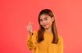 Young attractive asian girl smiling with heart finger sign in studio