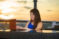 Young attractive Asian Korean business woman working online with laptop computer from rooftop sky bar on beautiful sunset as Royalty Free Stock Photo