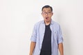 Young attractive asian man in casual shirt looking at camera with feeling amazed, excited or shocked face with open mouth on Royalty Free Stock Photo