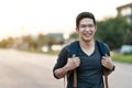 Young attractive asian man or college guy holding backpack smiling at camera feeling excited, happy vacation, joy and positive Royalty Free Stock Photo