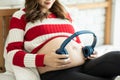 Young Attractive Asian pregnant woman listen music and lying on bed in the room Royalty Free Stock Photo