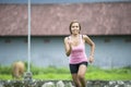 Young attractive Asian sport runner woman running in the jungle smiling happy in training workout on herb with countryside backgro Royalty Free Stock Photo