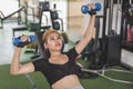 A young and attractive asian woman does alternating incline dumbbell bench presses. Working out chest and upper body at the gym Royalty Free Stock Photo