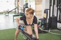 A young and attractive asian woman does one arm dumbbell rows on a flat bench. Working out back muscles at the gym Royalty Free Stock Photo