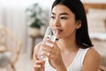 Young attractive asian woman drinking water, copy psace Royalty Free Stock Photo