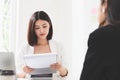 A young attractive asian woman is interviewing for a job. Her interviewers are diverse