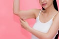 Young attractive Asian woman pinching excess fat and cellulite in her upper arms as she lacks exercise and healthy lifestyle. Royalty Free Stock Photo