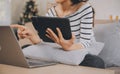 Young attractive asian woman resting using browsing tablet computer on sofa at home, happy girl sitting on couch relax reading Royalty Free Stock Photo