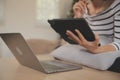 Young attractive asian woman resting using browsing tablet computer on sofa at home, happy girl sitting on couch relax reading Royalty Free Stock Photo