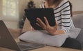 Young attractive asian woman resting using browsing tablet computer on sofa at home, happy girl sitting on couch relax reading Royalty Free Stock Photo