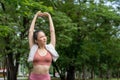 Young attractive Asian woman stretching her arms and legs before her morning exercise run at running track of a local park Royalty Free Stock Photo