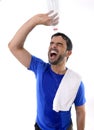 Young attractive and athletic sport man exhausted pouring water on his face