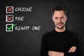 Young man with crossed arms and `Choose the right one` text on a blackboard background