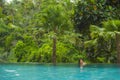 Lifestyle portrait of young attractive and beautiful Asian Chinese woman relaxing happy at tropical beach resort swimming at hotel Royalty Free Stock Photo