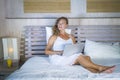 Young attractive and beautiful happy woman 30s lying in bed at home using internet working on computer laptop thinking and smiling Royalty Free Stock Photo