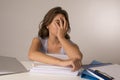 Young attractive and beautiful tired student girl leaning on school books pile sleeping tired and exhausted after studying Royalty Free Stock Photo