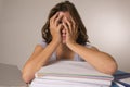 Young attractive and beautiful tired student girl leaning on school books pile sleeping tired and exhausted after studying Royalty Free Stock Photo