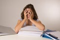 Young attractive and beautiful tired student girl leaning on school books pile sleeping tired and exhausted after studying Royalty Free Stock Photo