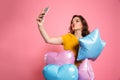 Young attractive birthday girl with balloons taking selfie on sm