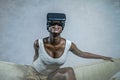 Young attractive black afro American woman playing VR goggles headset trying to touch illusion at living room couch Royalty Free Stock Photo