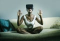 Young attractive black afro American woman playing VR goggles headset trying to touch illusion at living room couch Royalty Free Stock Photo