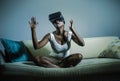 Young attractive black afro American woman playing amazed and surprised virtual reality video game wearing VR goggles