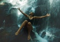 Young attractive and blissful Asian Indonesian woman overwhelmed by the beauty of natural waterfall in tropical jungle enjoying Royalty Free Stock Photo