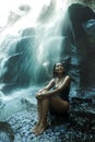 Young attractive and blissful Asian Indonesian woman overwhelmed by the beauty of natural waterfall in tropical jungle enjoying Royalty Free Stock Photo