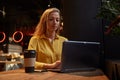 young attractive blond cauasian woman sitting at coffe shop, working on laptop