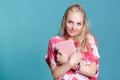Young attractive blond woman holding pink book on blue background