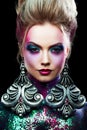 Young attractive blonde girl in bright art-makeup, high hair, body painting. Rhinestones and glitter Royalty Free Stock Photo