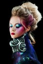 Young attractive blonde girl in bright art-makeup, high hair, body painting. Rhinestones and glitter Royalty Free Stock Photo