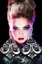 Young attractive blonde girl in bright art-makeup, high hair, body painting. Rhinestones and glitter Royalty Free Stock Photo