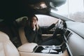 Young attractive blonde uses phone while sitting in car. Lifestyle and cars