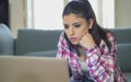 Young attractive and bored latin woman on her 30s working at home living room sitting on couch with laptop computer in stress look Royalty Free Stock Photo