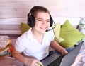 Attractive boy pensive, dreamy in a white t-shirt and jeans, in headphones is studying with a books and a laptop. Distance Royalty Free Stock Photo