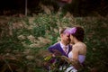 Young attractive bridal couple holding hands outdoors next to tree by lake Royalty Free Stock Photo